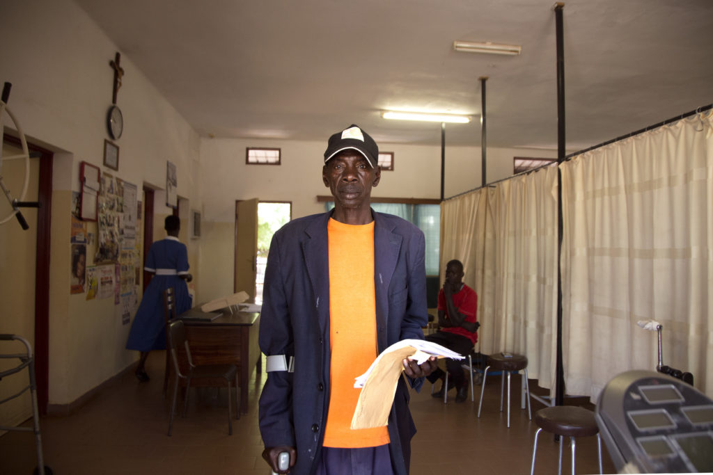 John Ewi poses for a picture shortly before his physiotherapist arrives to get him started on today's session